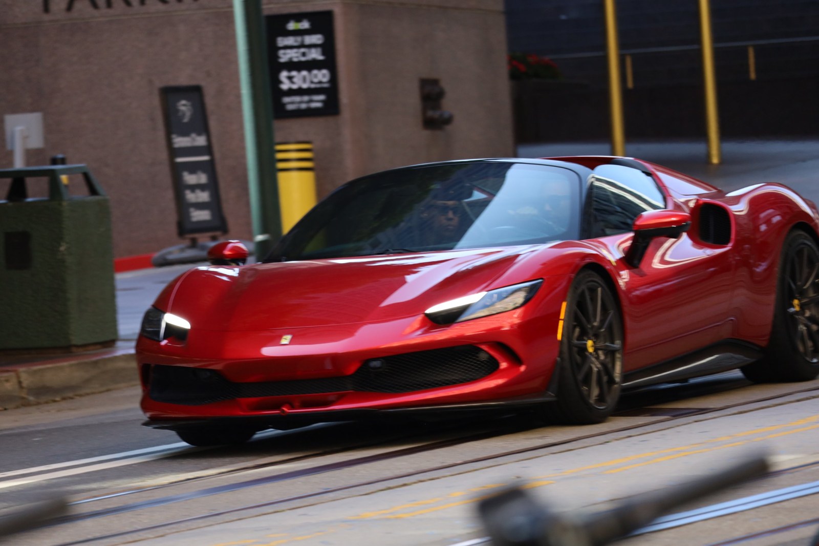 Red Ferrari driving along Market Street in San Francisco